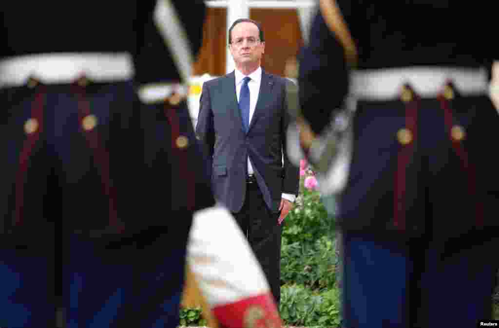 Francois Hollande attends a military ceremony in the garden of the Elysee Palace following his investiture in Paris, May 15, 2012.
