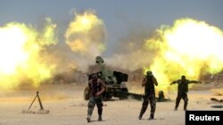 Shi'ite fighters with Iraqi security forces fire artillery during clashes with Islamic State militants near Falluja, Iraq, May 29, 2016.