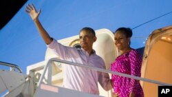 Predsednik Obama i prva dama Mišel prilikom sinoćnjeg ulaska u predsednički avion u vojnoj bazi u Honoluluu na Havajima