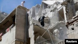 Residents look for survivors among the debris and damage after what activists said was shelling from forces loyal to Syria's President Bashar al-Assad at Al-Kallaseh in Aleppo, Syria, May 17, 2014.