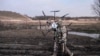 FILE - In this handout photo taken from video released by the Russian Defense Ministry Press Service on March 25, 2024, a Russian soldier carries a captured Ukrainian drone.