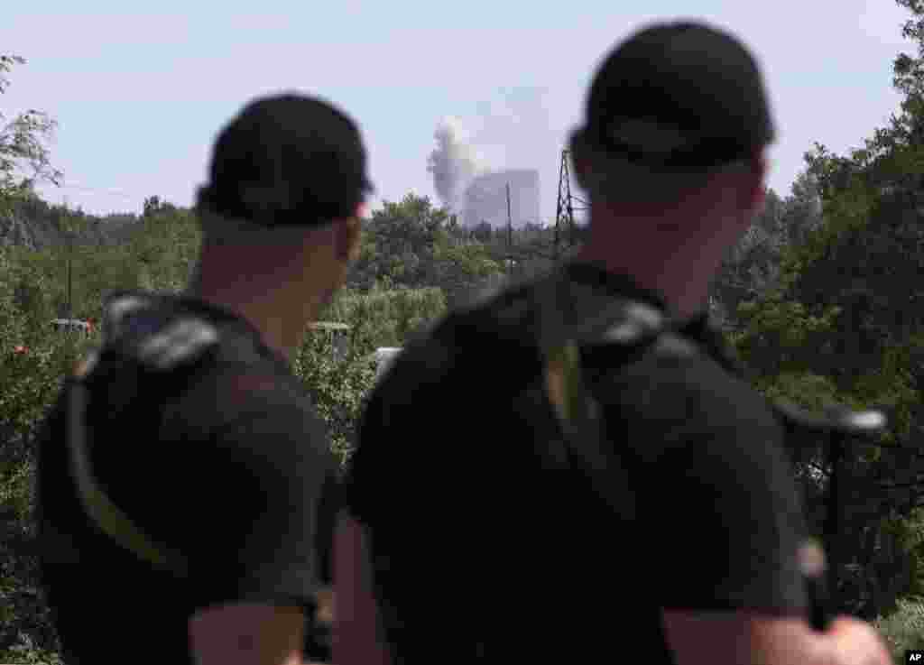 Self-proclaimed Donetsk People&#39;s Republic policemen watch shelling in Shakhtarsk, Donetsk region, eastern Ukraine, July 28, 2014.