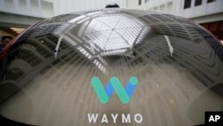 In this Dec. 13, 2016, file photo, a skylight is reflected in the rear window of a Waymo driverless car during a Google event in San Francisco. Google's robotic car spin-off Waymo is poised to become the first to test fully driverless vehicles on Californ