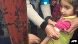 A handout picture released by UNICEF and taken Jan. 14, 2016, shows a UNICEF employee measuring the arm of a malnourished child in the besieged Syrian town of Madaya, as they assess the health situation of residents of the famine-stricken town.