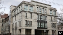 FILE - A women enters the four-story building known as the "troll factory" in St. Petersburg, Russia, where employees work around the clock writing blogs and posting comments on the Internet staunchly supporting President Vladimir Putin and attacking the West. (AP Photo/Dmitry Lovetsky)