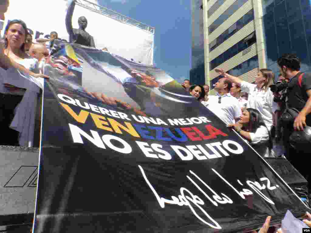 Líderes opositores sostienen un cartel recordando la figura del líder opositor Leopoldo López, quien lleva encarcelado un año. [Foto: Alvaro Algarra, VOA]