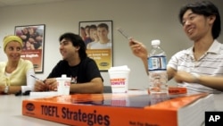 FILE - Yoshihiko Iwasaki from Japan, right, speaks during a Test of English as a Foreign Language, TOEFL, class at Kaplan, a test-prep school, in Boston, Thursday, Sept. 22, 2005.