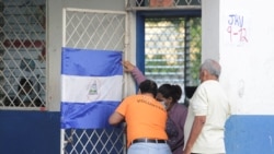Trabajadores electorales colocan una bandera nicaragüense en la puerta de un aula, en una escuela utilizada como centro de votación durante las elecciones presidenciales del país en Managua, Nicaragua, el 7 de noviembre de 2021. REUTERS 