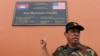 Cambodia's Ministry of Defense spokesperson Chhun Socheat shows a sign donated by the US during a government organized media tour to the Ream naval base in Preah Sihanouk province on July 26, 2019. 