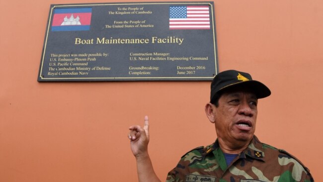 Cambodia's Ministry of Defense spokesperson Chhun Socheat shows a sign donated by the US during a government organized media tour to the Ream naval base in Preah Sihanouk province on July 26, 2019.