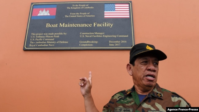Cambodia's Ministry of Defense spokesperson Chhun Socheat shows a sign donated by the US during a government organized media tour to the Ream naval base in Preah Sihanouk province on July 26, 2019.