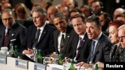 U.S. President Barack Obama, third from left, and British Prime Minister David Cameron, fourth from left, listen to NATO Secretary General Anders Fogh Rasmussen, third from right, as they participate in NATO Summit Session One, on Afghanistan and the Isla