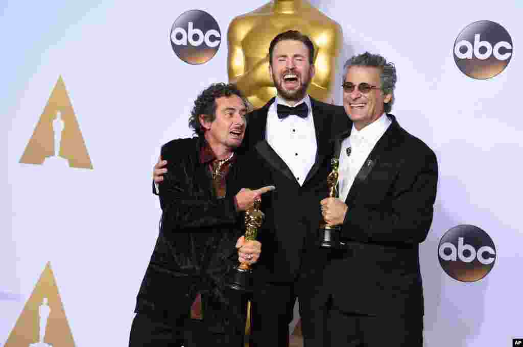 Chris Evans, tengah, berpose di ruang pers dengan David White, kiri, dan Mark Mangini, pemenang penyuntingan suara terbaik &ldquo;Mad Max: Fury Road&rdquo;, di acara Oscars hari Minggu, 28 Februari di Dolby Theatre, Los Angeles.