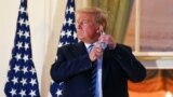 U.S. President Donald Trump pulls off his protective face mask as he poses atop the Truman Balcony of the White House after returning from being hospitalized at Walter Reed Medical Center for coronavirus disease (COVID-19) treatment, in Washington, Oct. 5, 2020 (REUTERS/Erin Scot