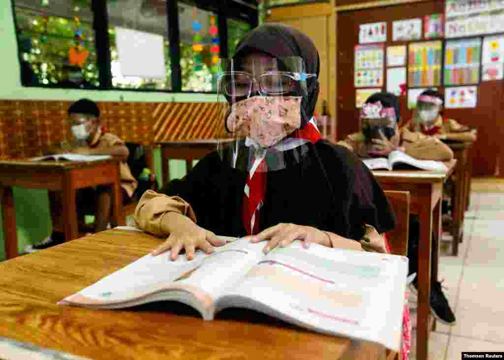 인도네시아 자카르타 초등학교가 대면 수업을 재개한 가운데 학생들이 신종 코로나바이러스 예방을 위한 마스크와 안면보호대를 쓰고 수업을 듣고 있다. 
