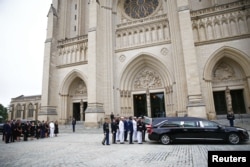 已故参议员约翰·麦凯恩的家人2018年9月1日在华盛顿的国家大教堂前观看他的灵柩抵达。
