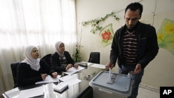 A man casts his vote in Damascus, Syria, December 12, 2011.