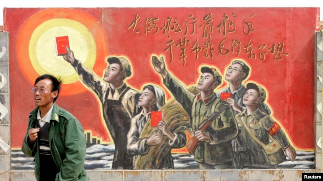 資料照：一名男子走過寧夏銀川街頭郊區的一處描寫中國文革的宣傳畫。（2007年4月25日）