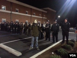 Protester in Anonymous mask posing in front of Ferguson police. He was later arrested, Nov. 19, 2014. (Ayesha Tanzeem/VOA)