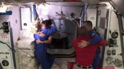 In this frame grab from NASA TV, astronaut Shannon Walker, second from left, is greeted by astronaut Kate Rubins, left, as she enters the International Space Station after arriving from the SpaceX Dragon capsule, early Tuesday, Nov. 17, 2020. At right, Ex