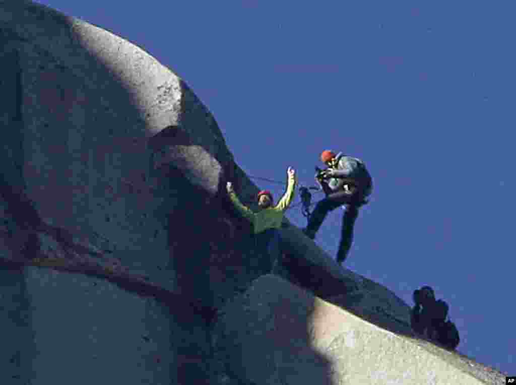 Tommy Caldwell (atas) mengangkat tangannya setelah berhasil mencapai puncak El Capitan di Taman Nasional Yosemite, California (14/1).