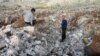 Syrian men stand inside crater where they said Scud missile landed December 13, 2012