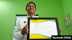 Kepala Puskesmas Tegalrejo, Abdul Latief dan papan ucapan selamat dari Mary Elizabeth Donalson. (Foto: VOA/Nurhadi)