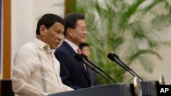 Philippine President Rodrigo Duterte (L) speaks with South Korean President Moon Jae-in during a joint press conference after their meeting at the presidential Blue House in Seoul, South Korea, June 4, 2018.