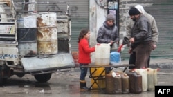 Syrians buy petrol on a street in the northwestern city of Idlib on December 30, 2016. A fragile calm is holding across Syria after a truce brokered by Russia and Turkey came into effect.