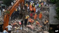 Rescuers sift through debris after a five-story building collapsed in the Ghatkopar area of Mumbai, India, July 25, 2017.