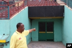 Congolese photographer Buddy Tshipamba points at the room from which boxer Muhammad Ali entered the stadium for his fight against George Foreman in Kinshasa, D.R.C., in October 1974.