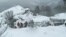 Members of Lazio's Alpine and Speleological Rescue Team stand in front of the Hotel Rigopiano in Farindola, Italy, that was hit by an avalanche, Jan. 19, 2017.