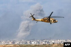 Helikopter angkut militer Black Hawk terbang di dekat perbatasan dengan wilayah Palestina di tengah berlanjutnya pertempuran antara Israel dan kelompok militan Hamas. (Foto: AFP)