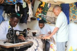 Jeffrey Phanga inspects the work of his trainees at his tailoring school in Malawi. (Lameck Masina/VOA)