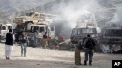 Cảnh sát Afghanistan canh gác gần các xe tải bị cháy sau vụ tấn công căn cứ Mỹ gần biên giới Pakistan, ngày 2/9/2013.