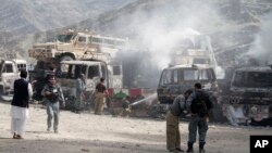 Afghan police stand guard near burning NATO supply trucks following an attack by militants on a U.S. base near the Pakistan-Afghanistan border, Sept. 2, 2013. 