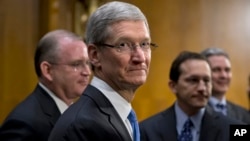 CEO Apple Tim Cook (tengah) dikelilingi timnya saat istirahat dari memberi kesaksian kepada Senat AS (21/5).