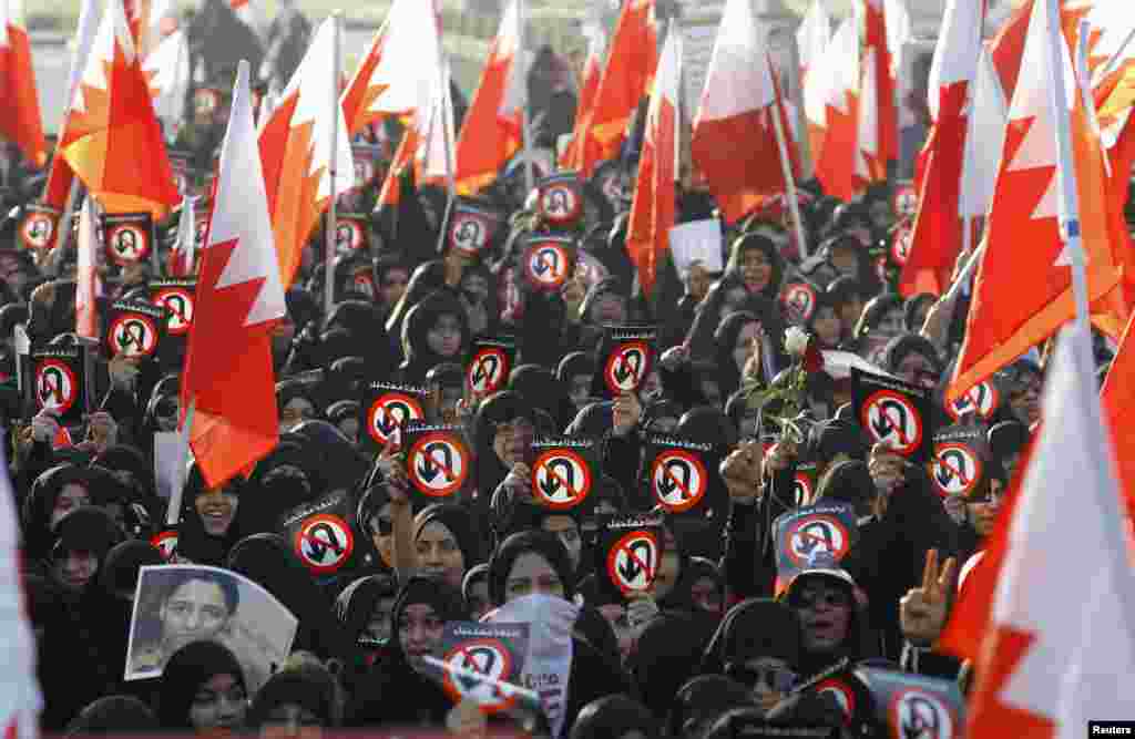 Protesters hold Bahraini flags and banners with signs reading&nbsp; &#39;No U Turn&#39; - meaning &#39;No Returning Back&#39; - in a rally organized by the main opposition society Al Wefaq, in Budaiya, west of Manama, Bahrain. 