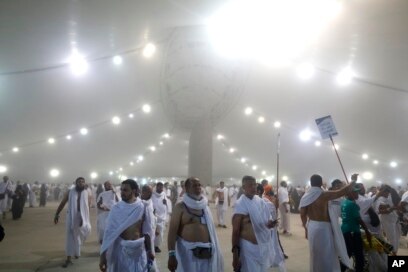 Peziarah berjalan setelah mereka melemparkan batu ke pilar yang melambangkan rajam Setan, dalam ritual yang disebut "Jamarat," ritual terakhir haji tahunan, pada hari pertama Idul Adha, di Mina dekat kota suci Mekah Arab Saudi (Foto: AP / Mosa`ab Elshamy)