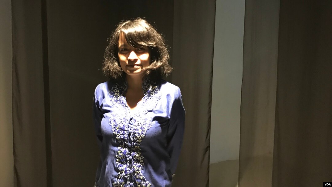 Feby Indirani berpose di instalasi "Ruang Tunggu" karya Maradita Sutantio (2018) dalam pameran "Bukan Perawan Maria". Pameran ini bagian dari gerakan "Relaksasi Beragama" sejak 2017. (Foto: Rio Tuasikal/VOA)