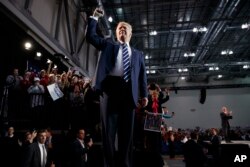FILE - Republican presidential candidate Donald Trump pumps his fist as he arrives to speak at a campaign rally in Grand Rapids, Mich., Nov. 8, 2016. President-elect Donald Trump inherits a much sturdier economy than the one Barack Obama did.