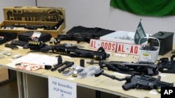 FILE - Belgian police displayed an arsenal they say was found in the home of a suspected terrorist whom they killed in a 2013 shootout in this March 27, 2013 photo.