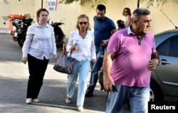 Turkish journalist Nazli Ilicak, center, a well-known commentator and former parliamentarian, is escorted by a police officer, right, and her relatives, at left and rear, after being detained and brought to a hospital for a medical check in Bodrum, Turkey, July 26, 2016.