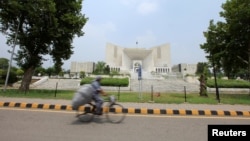 A man rides a bicycle past the Supreme Court building in Islamabad, Pakistan, June 27, 2016. 