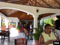 Haitian-American tourists check email on their mobile phones and check in at the Buccanier Beach Club hotel in Léogane, Haiti. (S. Lemaire/VOA)