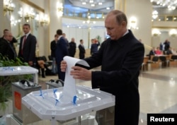 Russian President Vladimir Putin casts a ballot at a polling station during a parliamentary election in Moscow, Sept. 18, 2016.