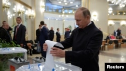 Presiden Rusia Vladimir Putin memasukkan surat suaranya ke dalam kotak suara di sebuah TPS dalam Pemilu Parlemen di Moscow, 18 September 2016. (Sputnik/Kremlin/Alexei Druzhinin via REUTERS) 