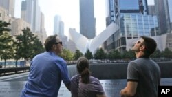 Visitors to the National September 11 Memorial take in the view from the north pool, Saturday, Sept. 10, 2016, in New York. Sunday marks the 15th anniversary of the attacks on the World Trade Center. (AP Photo/Mary Altaffer)