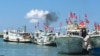 FILE - Taiwanese fishing boats flying national flags prepare to leave for the Taiwan-controlled Taiping Island from Taiwan's southern port city of Pingtung, July 20, 2016.