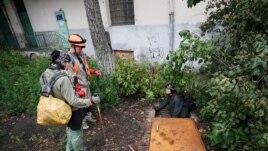 Diggers Andriy Ryshtun and Oleksandr Ivanov and historian Hanna Tychka prepare to go underground to explore the city sewage system. REUTERS/Gleb Garanich